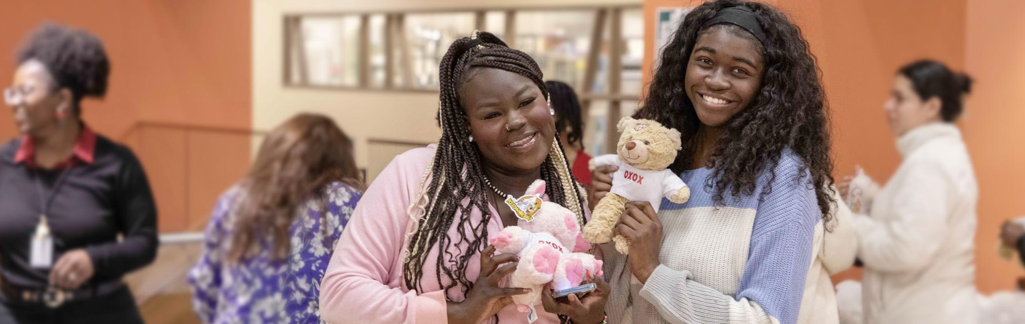 Students pose with build-a-valentine stuffed animals at the Southeast campus.